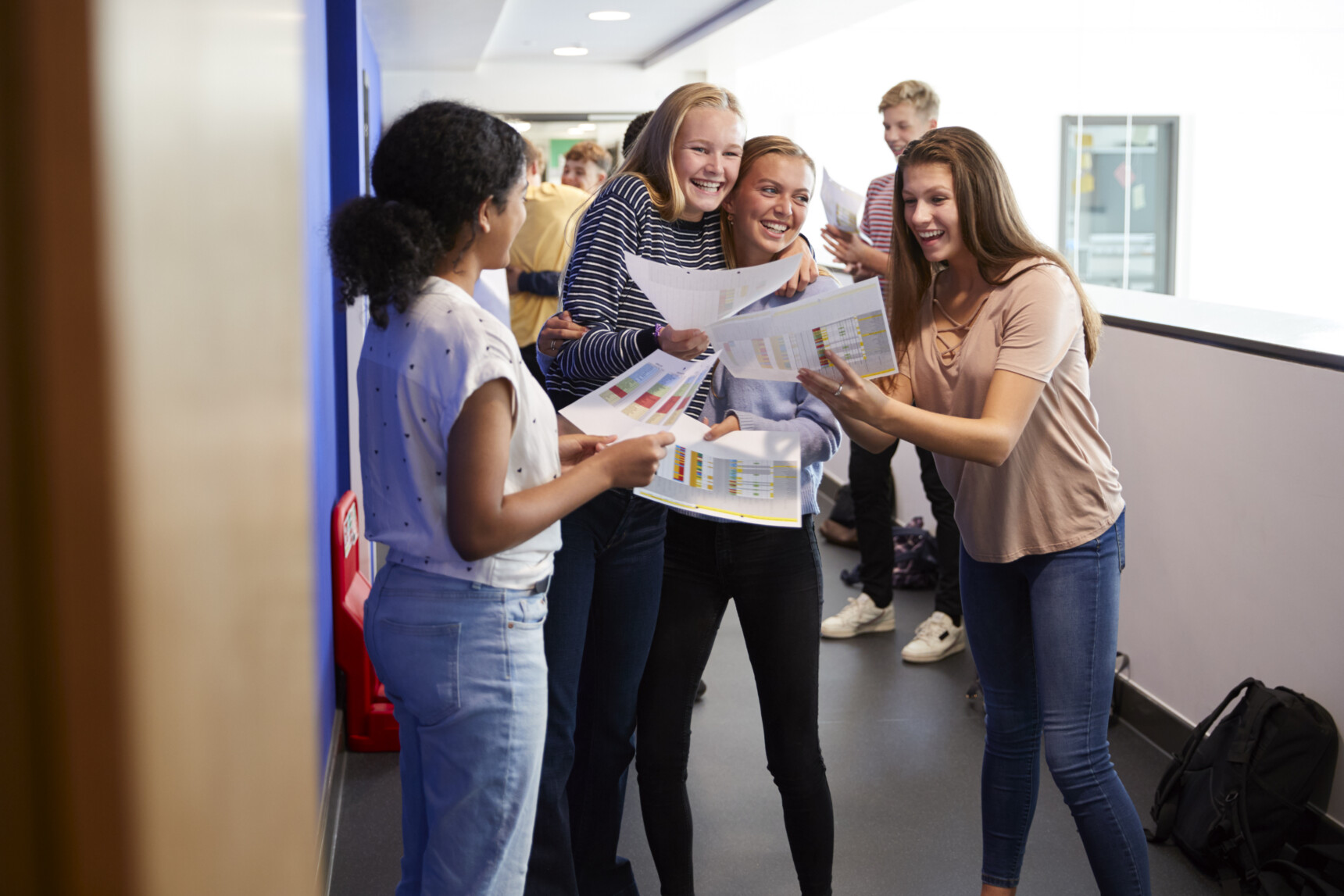 Students hugging and celebrating their A Level exam results.