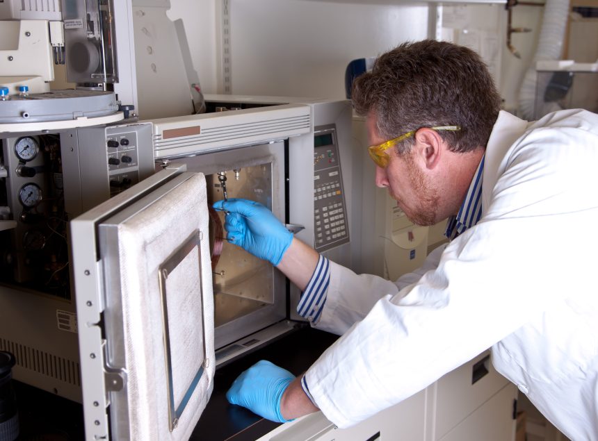 A scientist preparing a chromatograph oven.