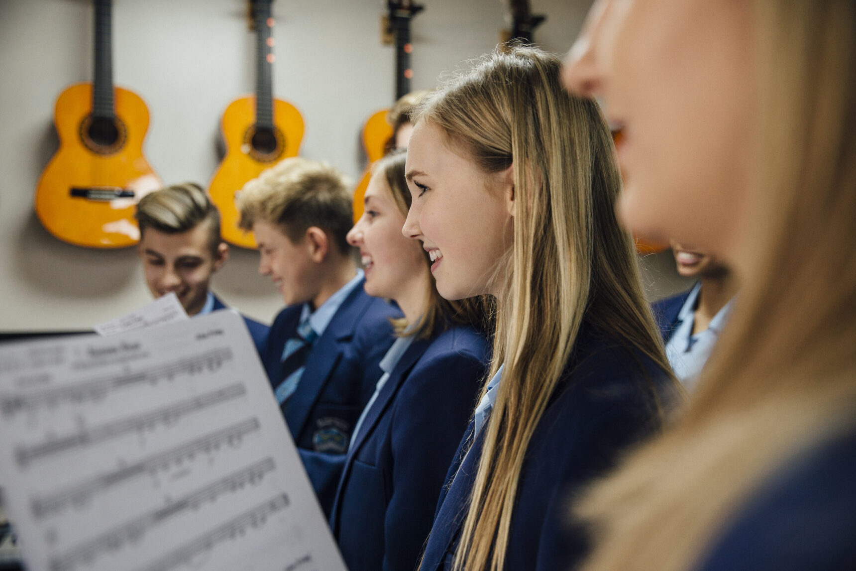 UK secondary school students singing in music class.