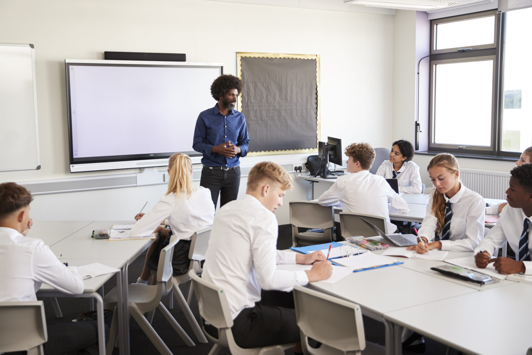 Male teacher in a UK secondary school teaching his class.