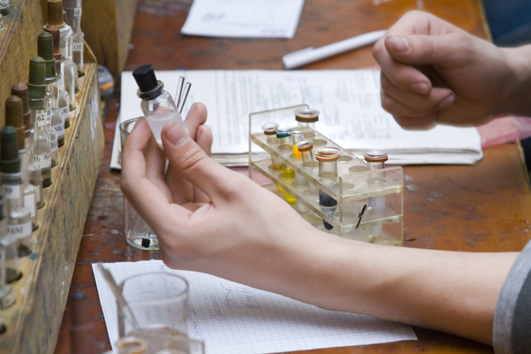 Student holding a solution in a chemistry practical experiment.