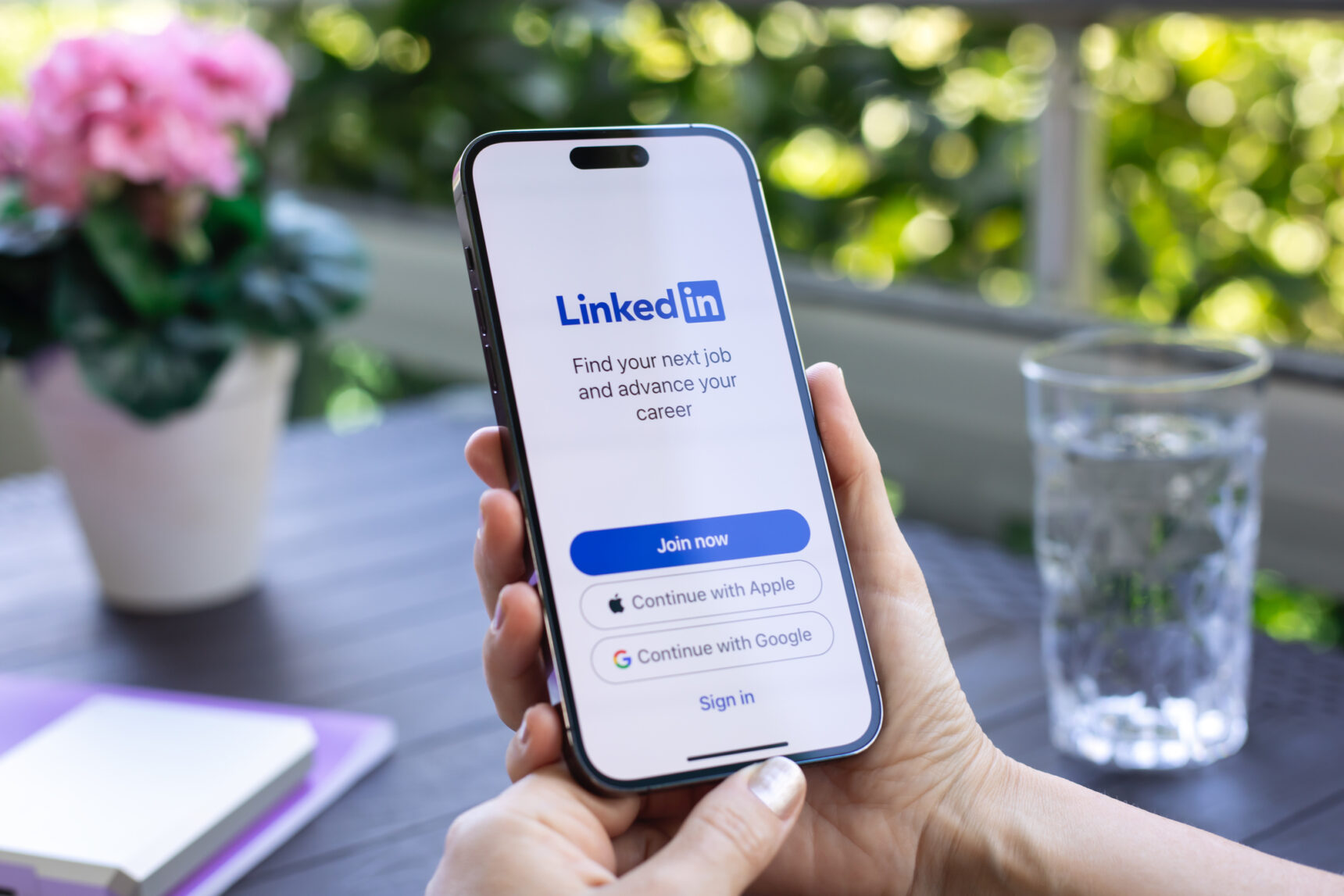 Hand holding an iPhone displaying LinkedIn. LinkedIn is an invaluable tool for networking and exploring career opportunities.