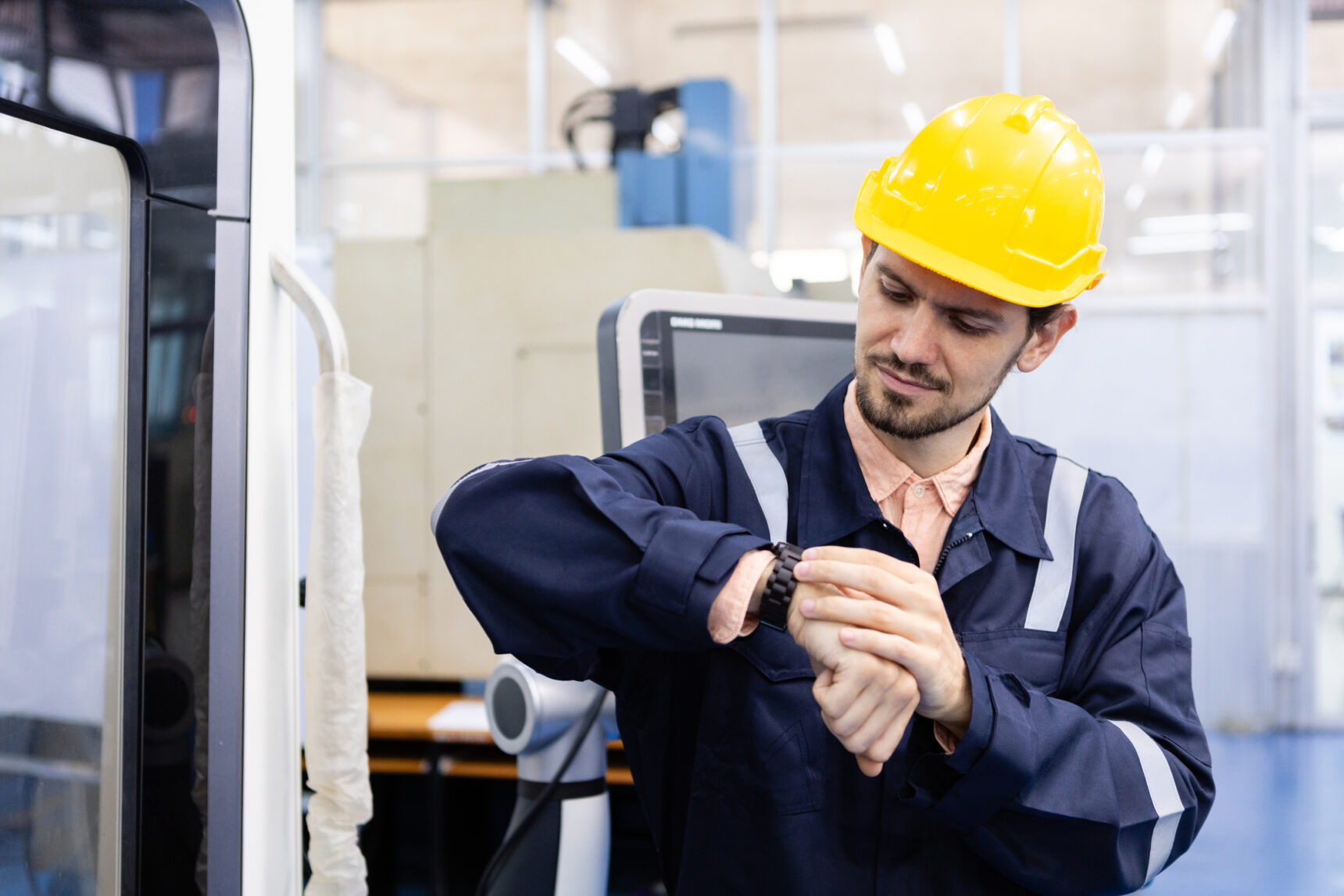 Man checking the time on his watch whilst at work.