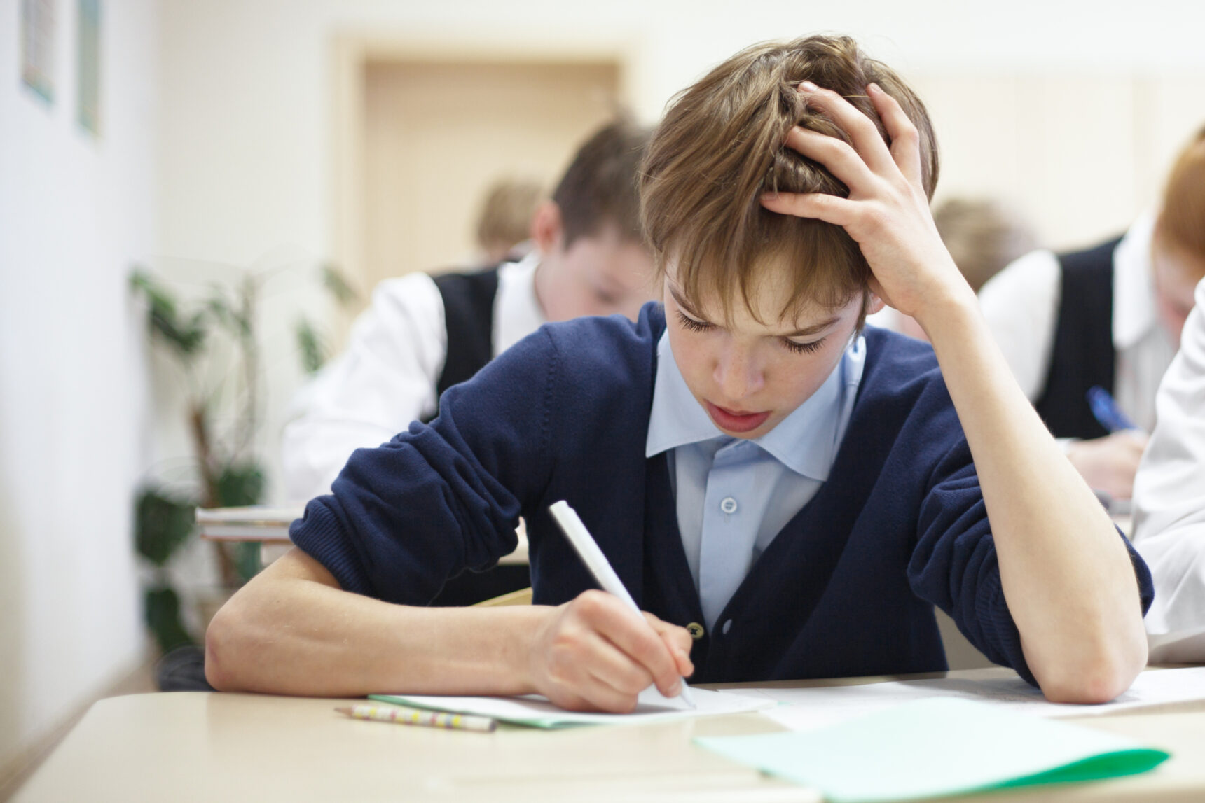 School boy with SEND struggling in class. SENCOs support students with SEND.