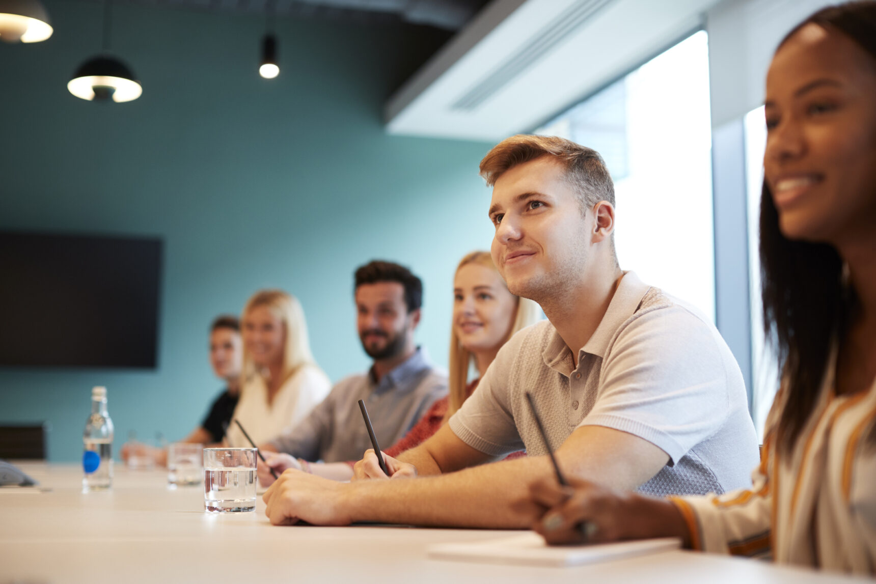 Students sat along a long table, writing their cover letters on paper and smiling.