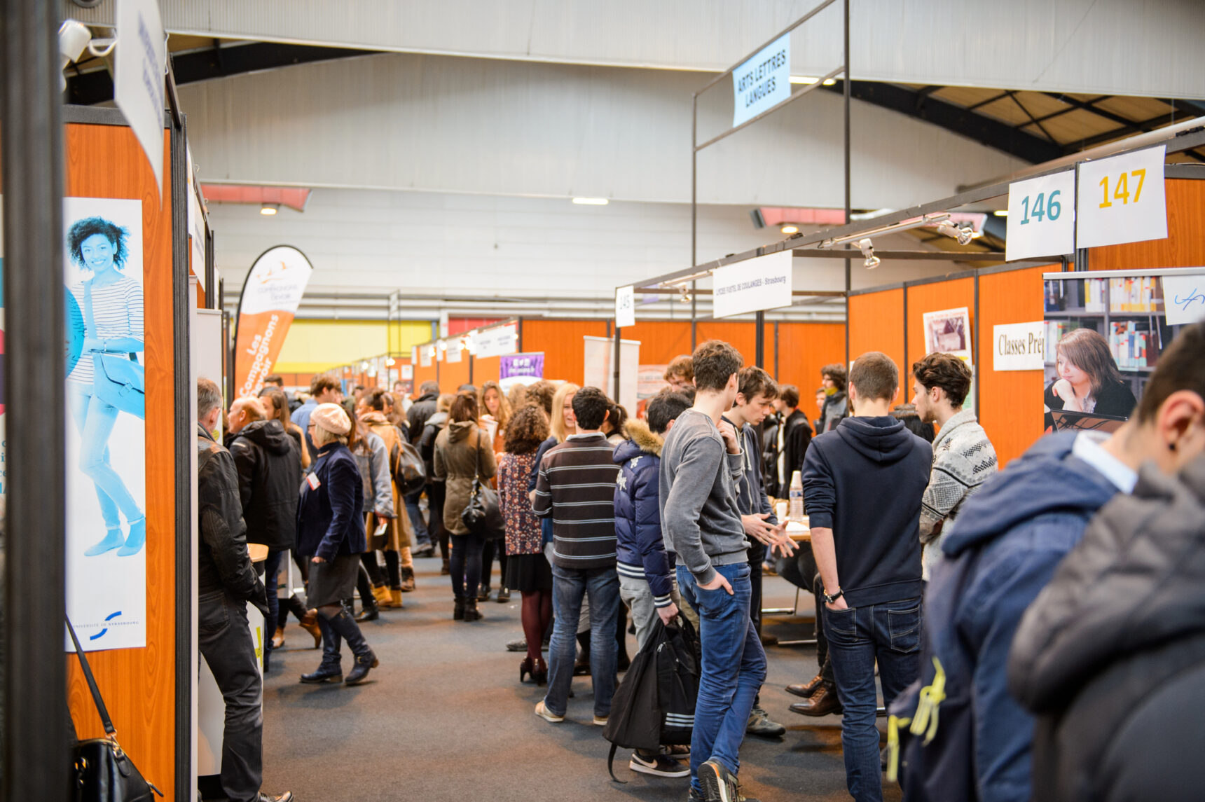 Bustling apprenticeship fair full of stalls and students.