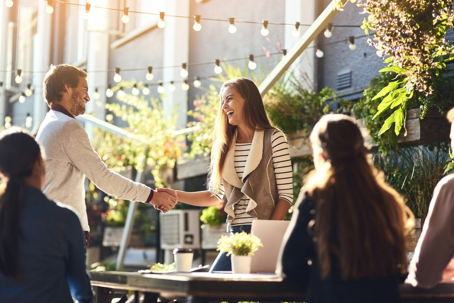 Colleagues shaking hands during a meeting, expanding their network.