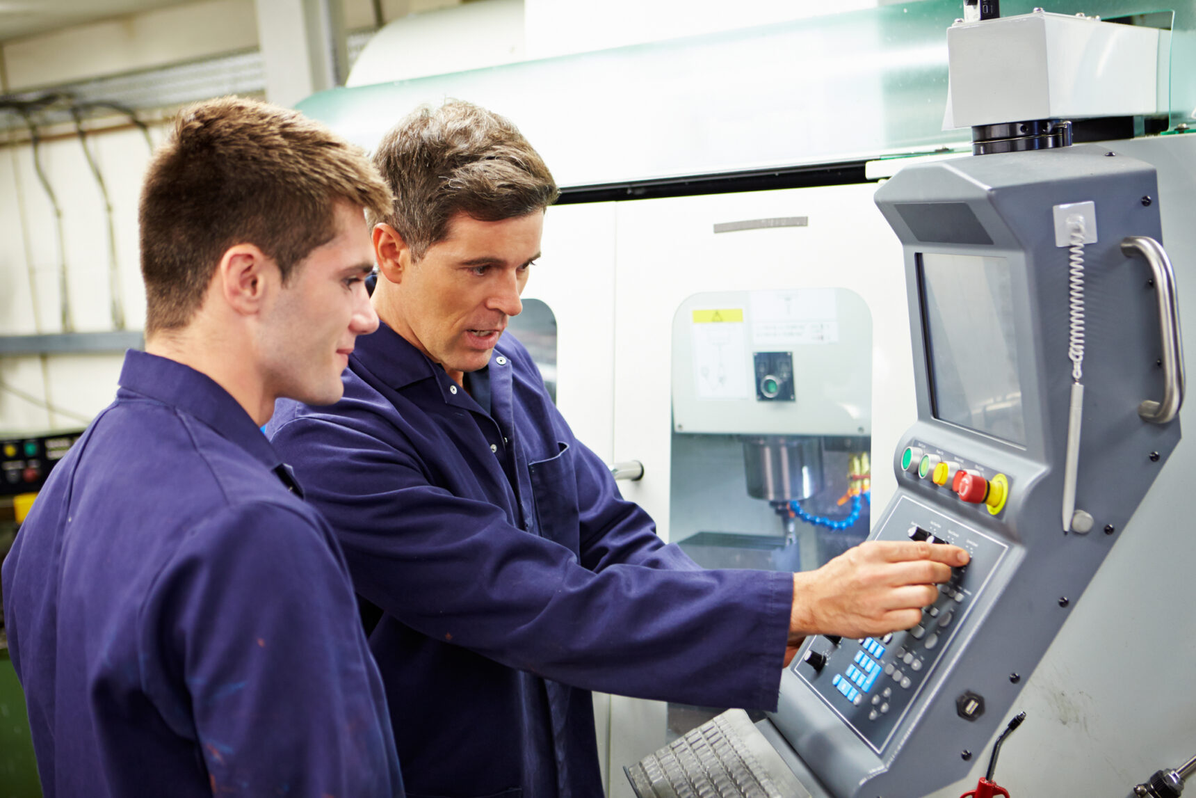 Engineer and degree apprentice using milling machine.