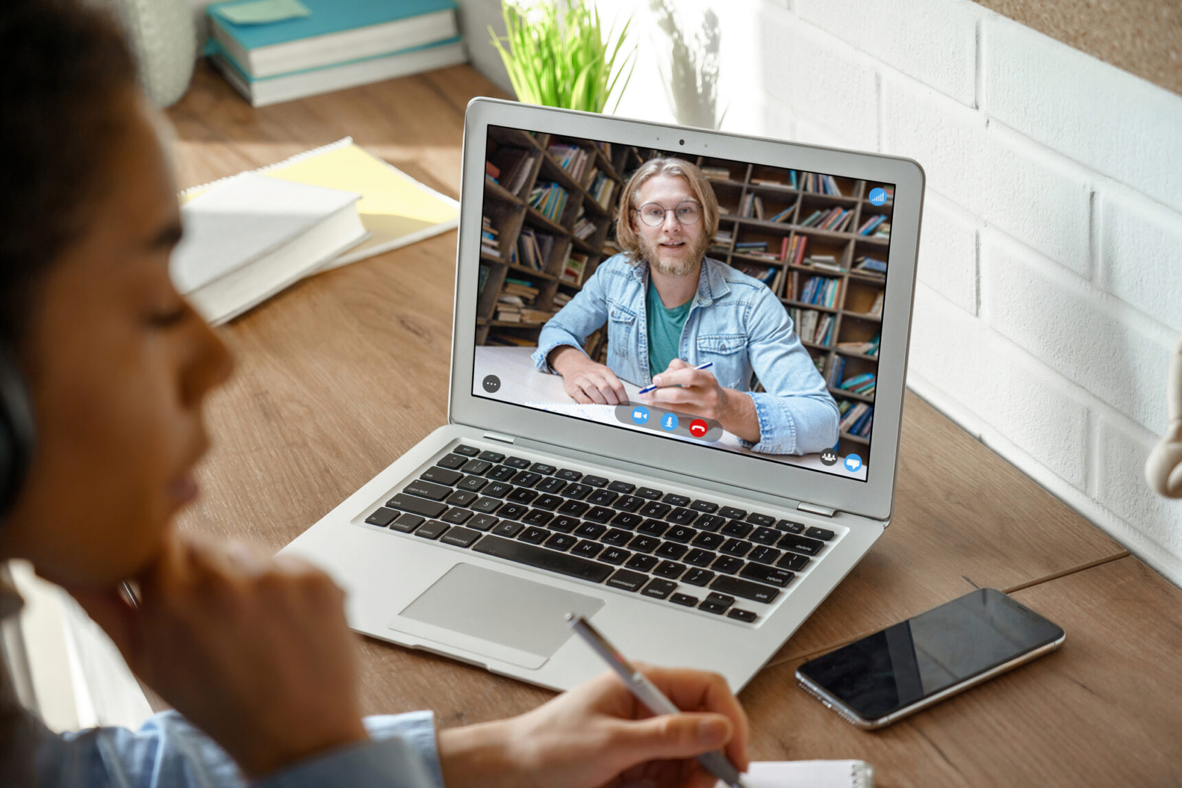 Online tutor visible on a laptop screen giving student constructive feedback.