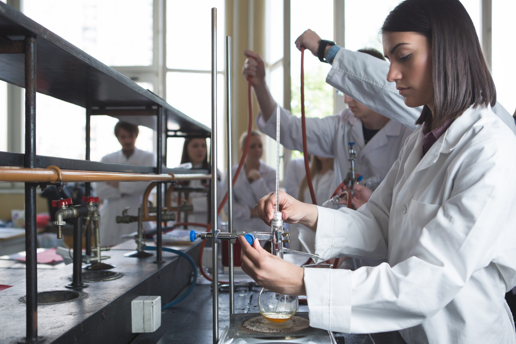 STEM chemistry Master's degree students setting up distillation equipment.