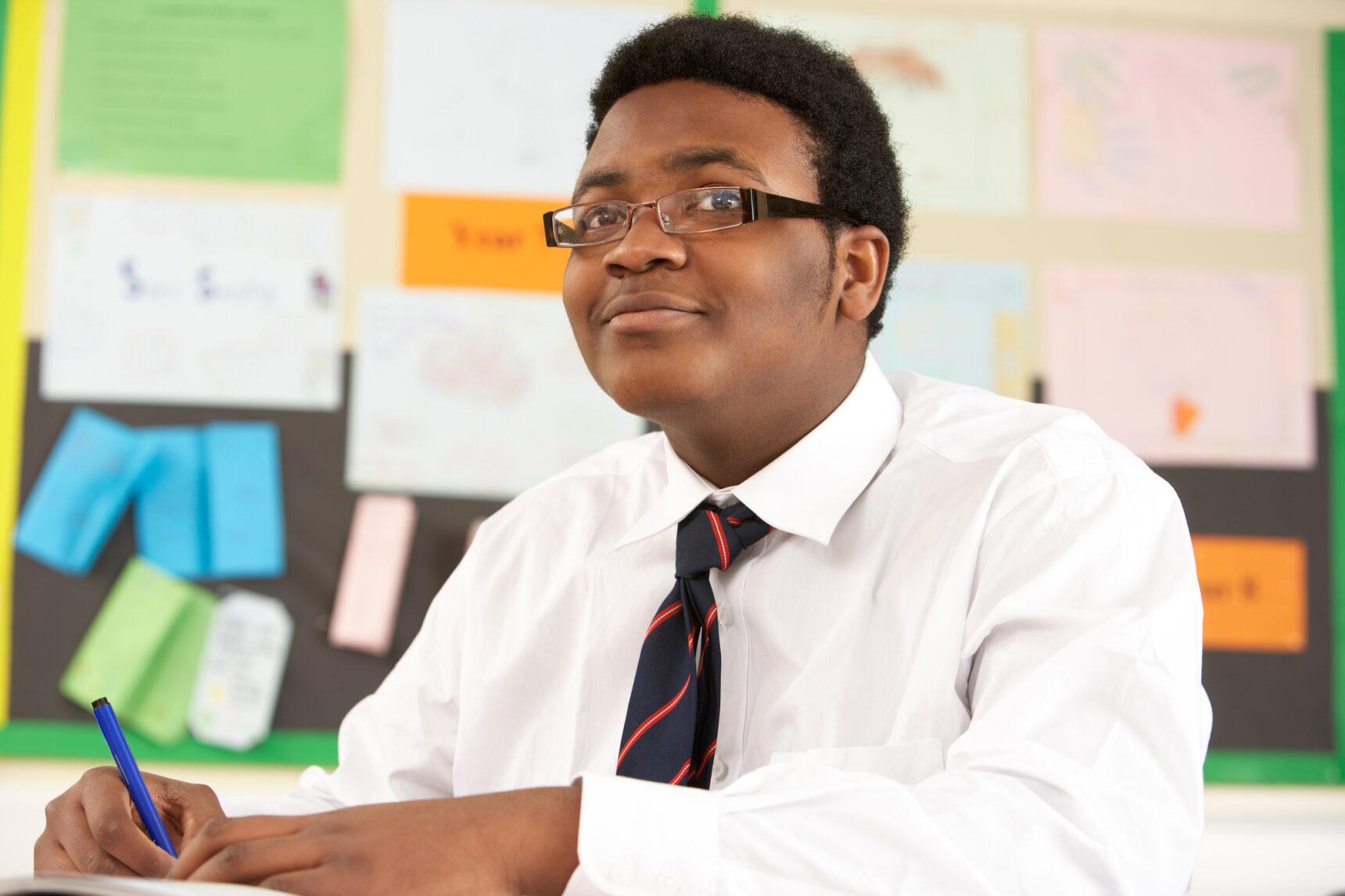 Male student listening to and watching teacher use visualiser.