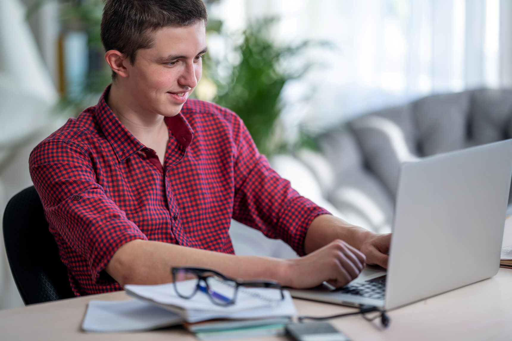 Male A Level student revising at laptop.