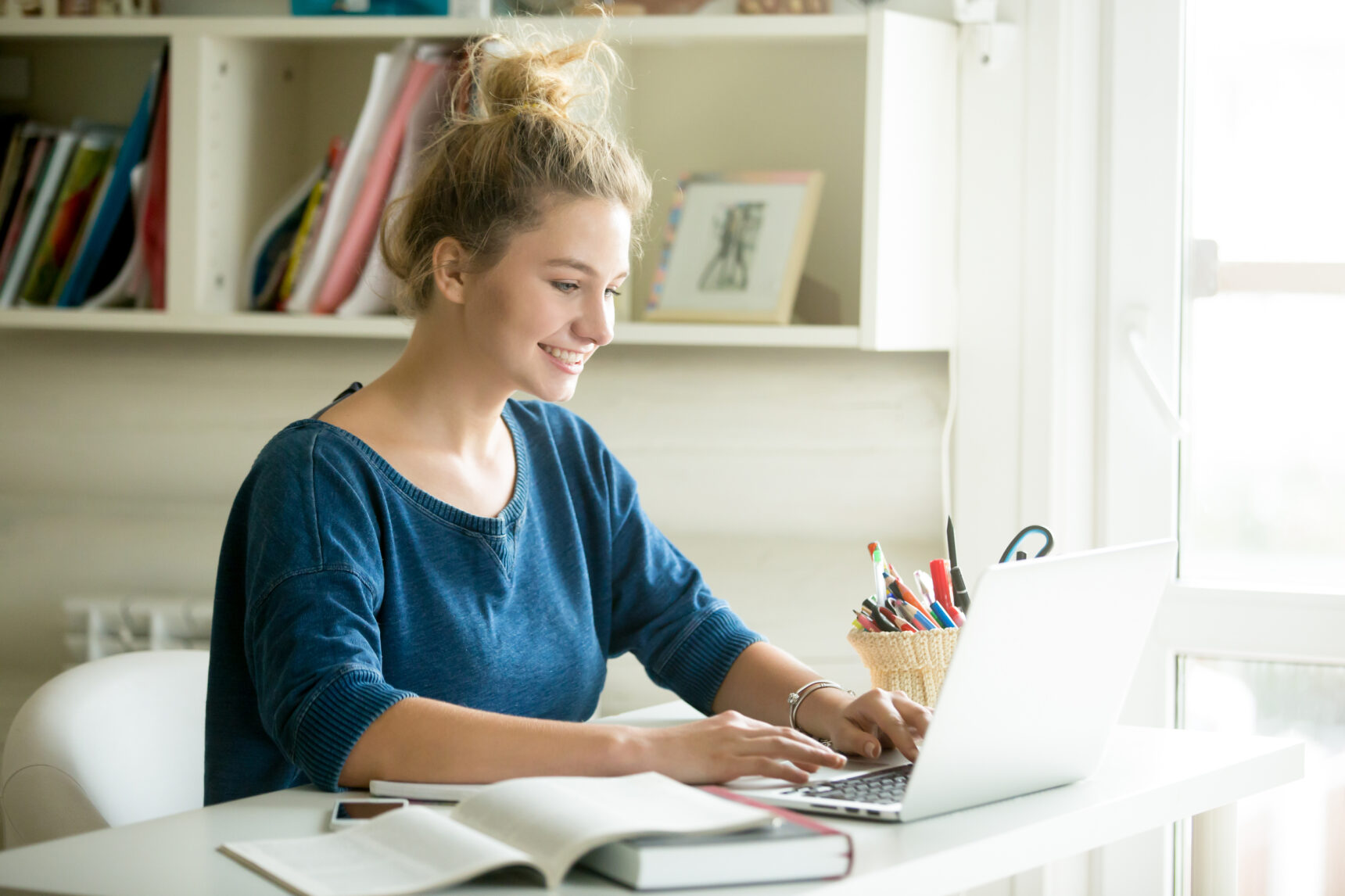 Female student receiving positive feedback and smiling at online tutor.