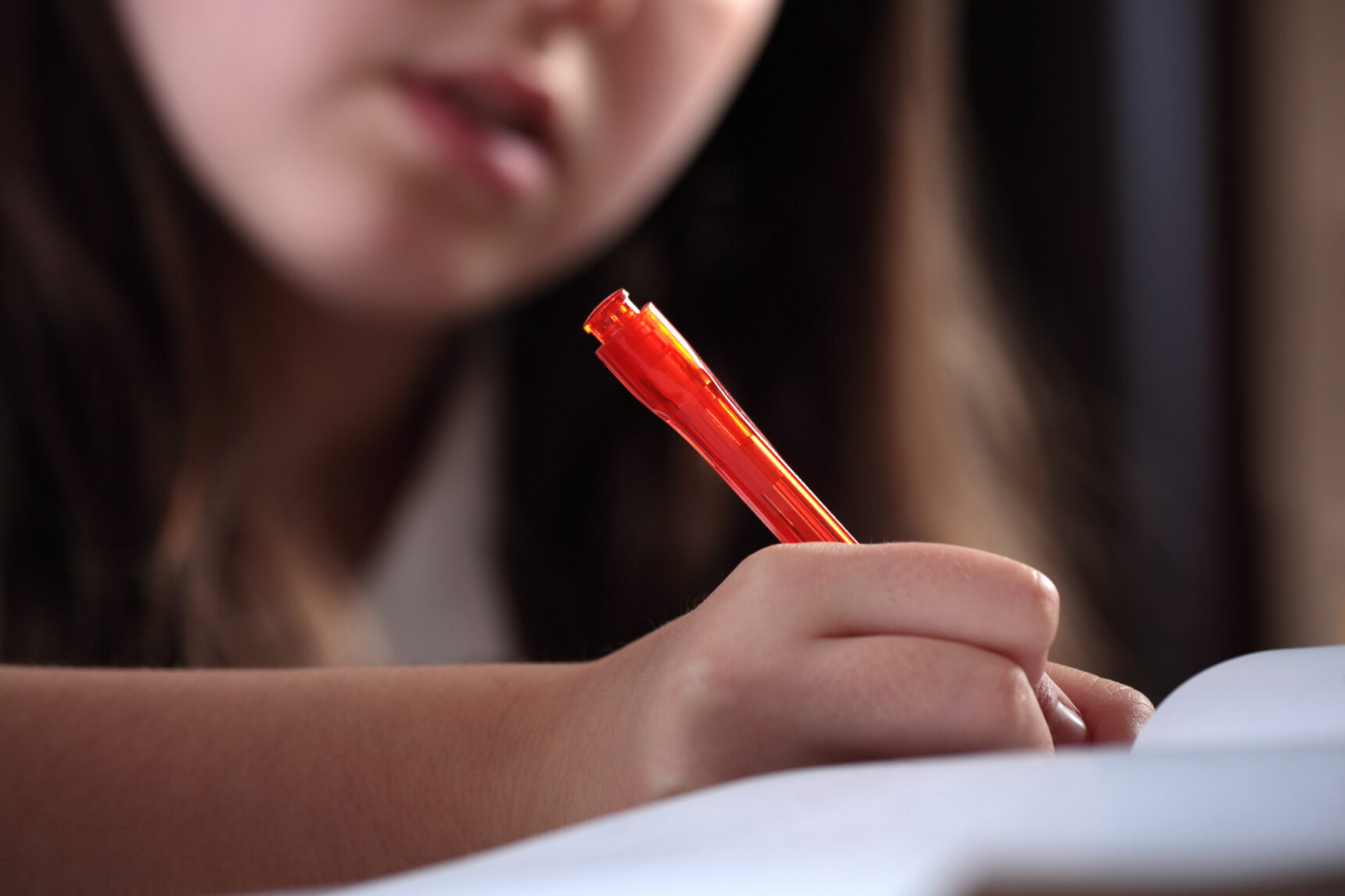 Girl writing essay in GCSE English exam.