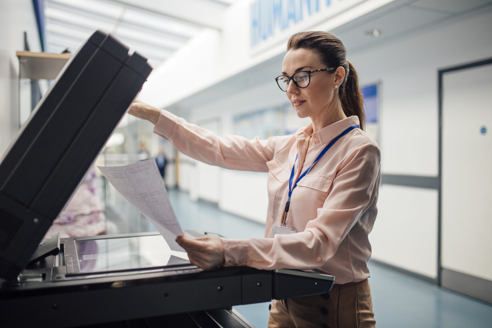 Female teacher using photocopier.