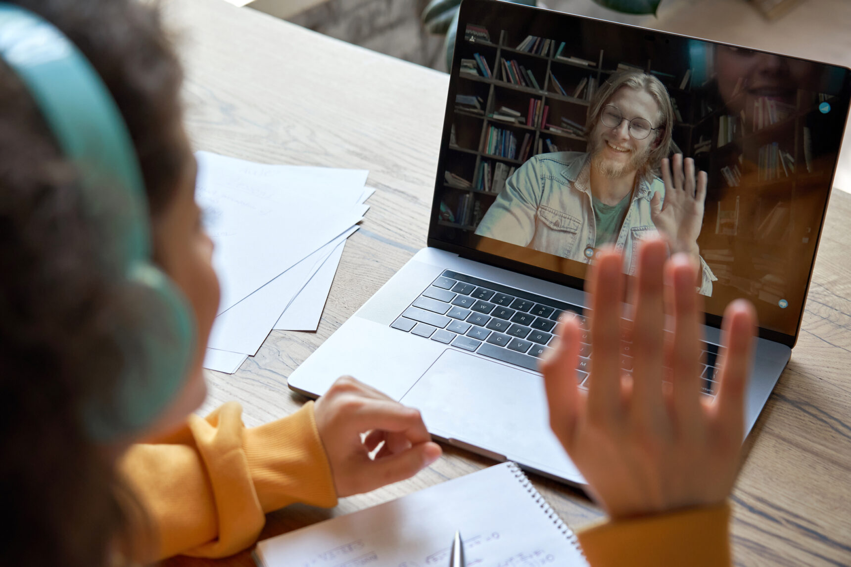 Student waving at their online tutor.