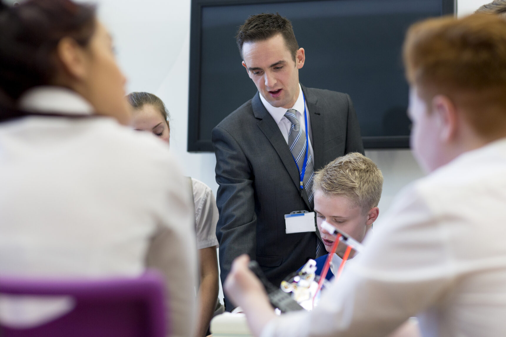 Male teacher interacting with students during Ofsted inspection.